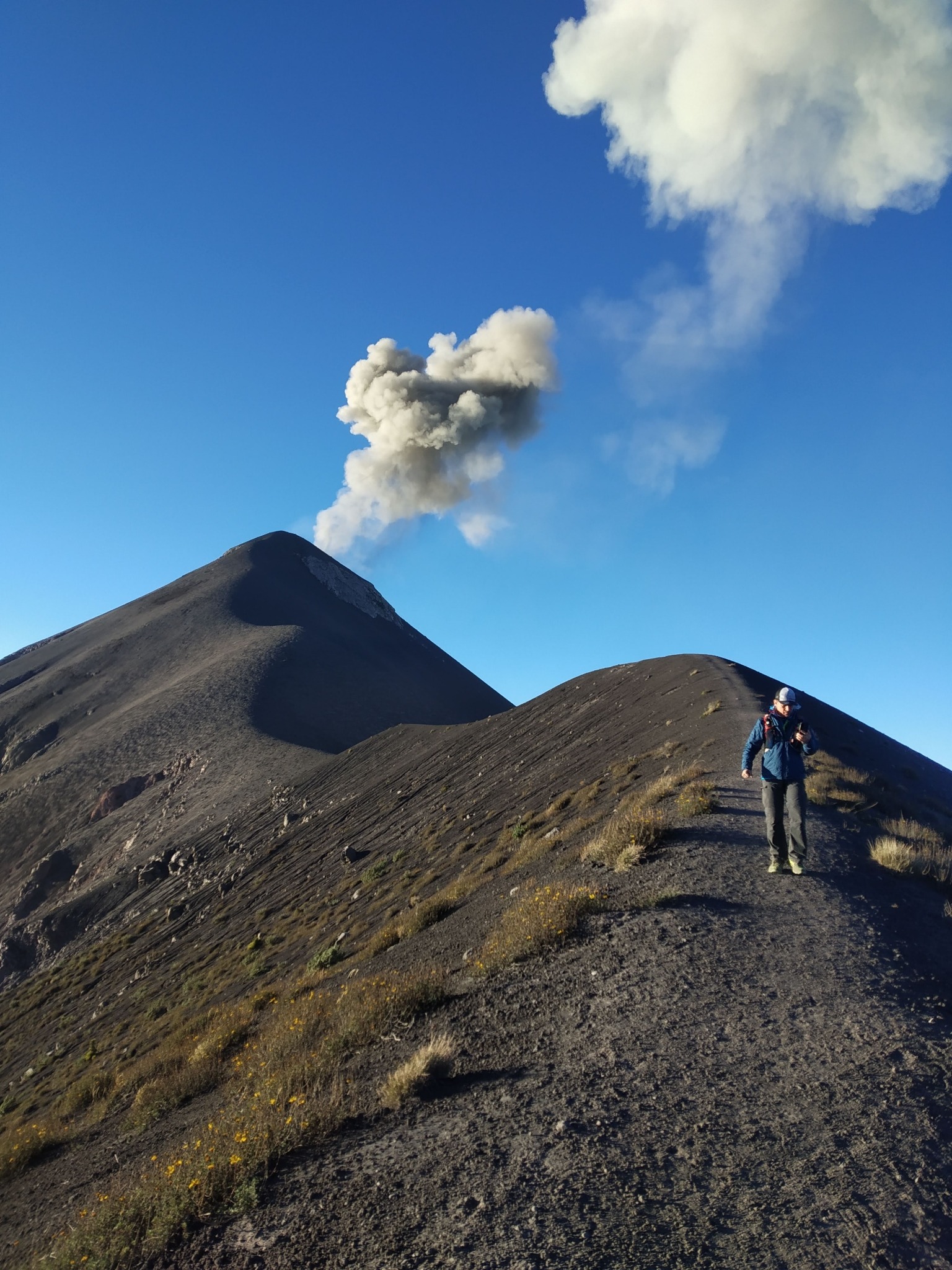 Fuego volcano releasing a plume of smoke against a blue sky